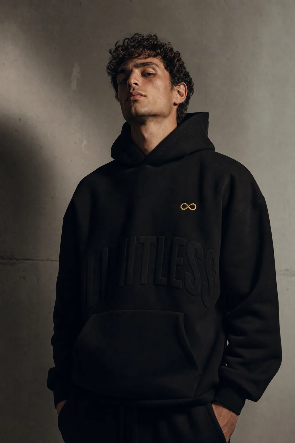 I AM luxury streetwear — premium black hoodie with embroidered gold infinity logo